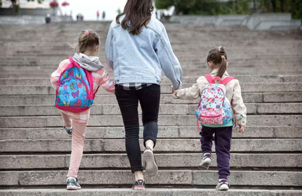 parent-pupil-primary-school-go-hand-hand-mom-two-girls-with-backpack-back-beginning-lessons-first-day-fall-scaled-r2pgb9ny6lf3llyo5fesyywniuhk1jff0a0fc9c31g