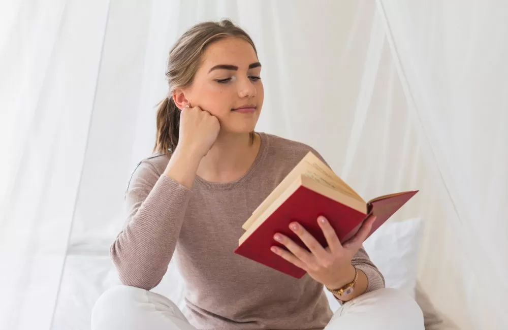 young-woman-sitting-bed-reading-book-scaled-r2ij2zy02l23eooowm51yl9kz7nxb34z3nxdz6lyec